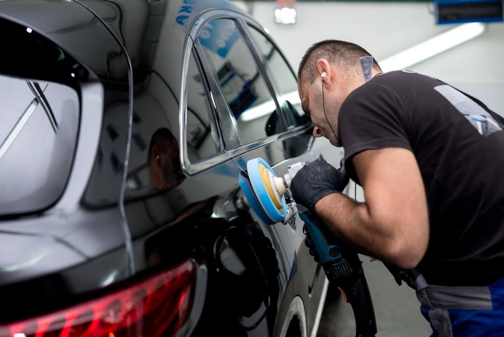 Car detailing expert from Nobleton waxing a car.
